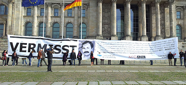 BMI verteilt "Vermisst" Postkarten am NSU-Tatort Plakattext: "Das ist Enver Şimşek. Er war das erste Opfer der NSU. Wir vermissen ihn und haben Angst, dass Behörden weiteres Beweismaterial geheim halten, vernichten und die Aufklärung bewusst verhindern. Wir haben Angst vor weiteren rassistischen Angriffen, weil leider immer noch Vorurteile und Hass gegen Muslime und Menschen, die ‚nicht deutsch genug‘ aussehen, gezielt geschürt werden. Wenn es Ihnen so geht wie uns, wenden Sie sich an die Beratungsstelle Radikalisierung." © MiG