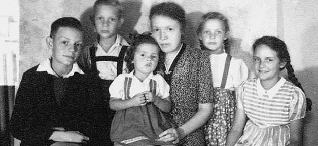 Die kinderreiche Flüchtlingsfamilie Sennlaub 1947. Rechts außen ist die große Schwester, die „Maria“ zu sehen. Der kleine „Engel“ sitzt auf Mutters Schoß © Zeitgut Verlag